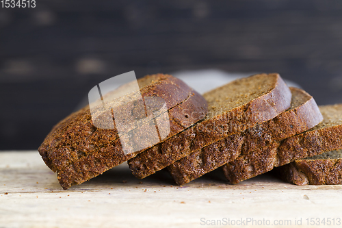 Image of bread sliced on wooden cutting Board