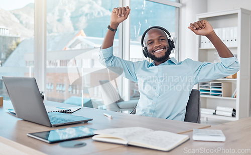 Image of Music, black man in office with headphones, dance and enjoying work with radio streaming app. Excited African businessman at desk with earphones, excited dancing and fun working on startup report.