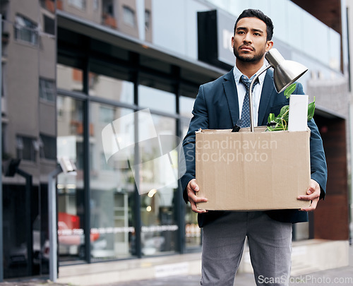 Image of Depression, economy and box with a business man walking outdoor in the city for unemployment. Financial crisis, fired and jobless young male employee with failure, sad and stress in an urban street