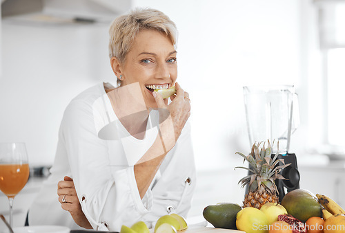 Image of Portrait, fruit salad and apple with an elderly woman in the kitchen of her home for health, diet or nutrition. Smile, food and cooking with a happy senior female pensioner eating healthy in a house