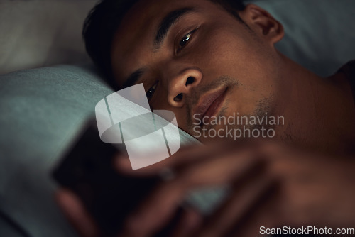 Image of Night, bed and face of man with phone addiction, internet or social media, texting with insomnia in home. Wake up, online chat and male in dark bedroom with cellphone, mobile game and digital app.