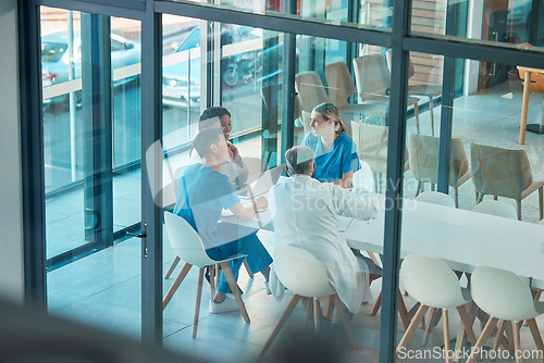 Image of Healthcare, doctors and team meeting with a laptop for a discussion, planning or research at table. Men and women medical group talking about communication strategy, virus or surgery in a hospital