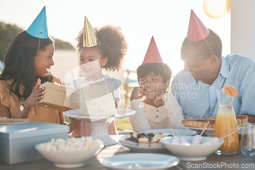 Image of Birthday, parents and children with cake in park for event, celebration and party outdoors together. Family, social gathering and mother, father with kids at picnic with cake, presents and surprise