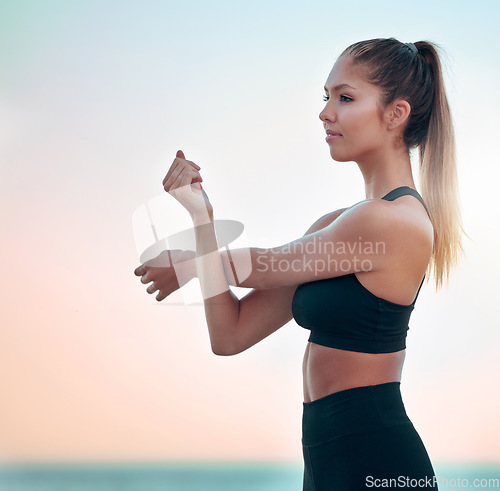 Image of Fitness, stretching arms and woman at beach for exercise, training and ocean mockup space. Sports, workout and female athlete stretch for health, wellness and body warm up for running at sunset.