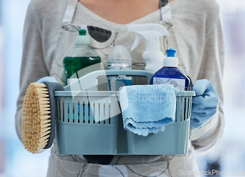 Image of Hands, basket and product for cleaning home with brush, cloth or chemical for hygiene by blurred background. House, professional cleaner woman or plastic container for services, stop bacteria or dust