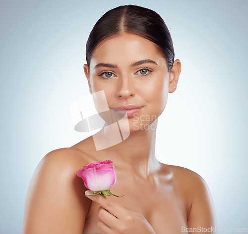 Image of Skincare, face and woman with rose flower in studio isolated on a white background. Spring portrait, natural plant and female model with pink floral for makeup cosmetics, beauty treatment or wellness