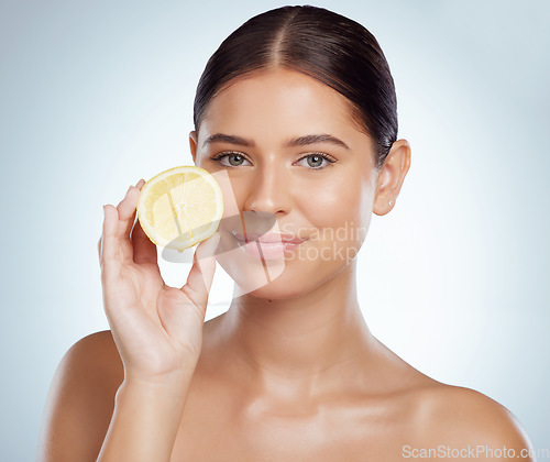 Image of Face, skincare and woman with lemon in studio isolated on a white background. Portrait, natural or female model with fruit for vitamin c, vegan nutrition or healthy diet, wellness or beauty cosmetics