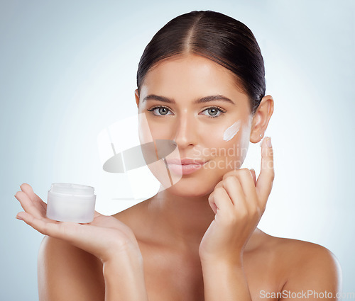 Image of Face, skincare and woman with cream container in studio isolated on a white background. Portrait, dermatology lotion and female model apply cosmetics, sunscreen or moisturizer product for skin health