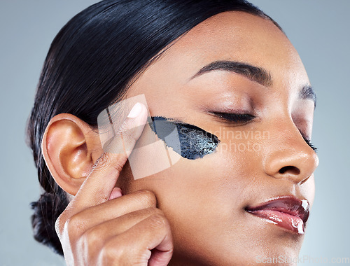 Image of Charcoal mask, face treatment and woman with cosmetics, natural beauty and skincare. Cosmetic, young female model and self care with mud facial and detox product for skin glow and wellness in studio