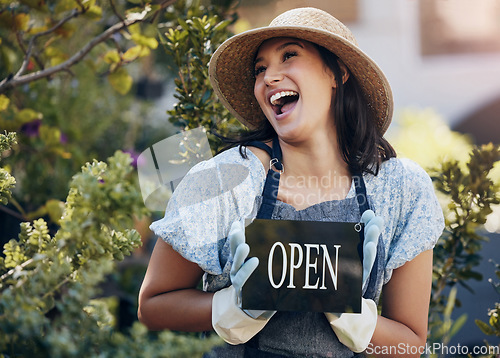 Image of Happy, nursery and open with a woman holding a sign outside of shop for gardening or landscaping. Small business, garden center and an excited young female entrepreneur opening her new floral store