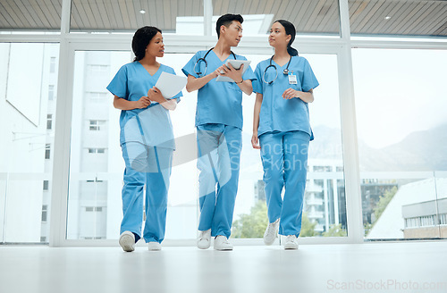 Image of Teamwork, discussion or medical students walking or planning a surgery strategy in collaboration. Internship, doctors or young surgeons with tablet talking, working or speaking of hospital healthcare