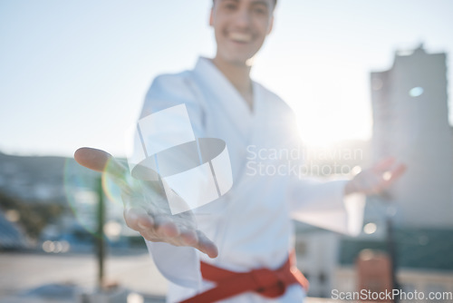 Image of Karate, hand and fighting with a sports man in gi, training in the city on a blurred background. Exercise, gesture or virtue with a happy male athlete during a self defense workout for health closeup
