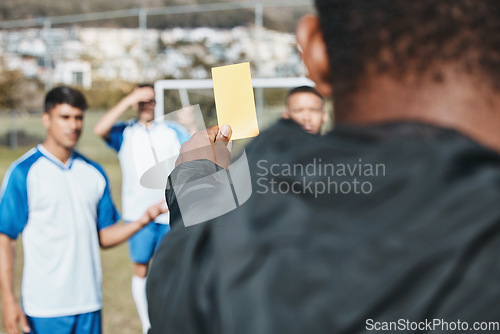Image of Sports team, yellow card and soccer referee outdoor on field for competition or game foul or rules. Football player, athlete club and person with paper in hand for warning, penalty or punishment