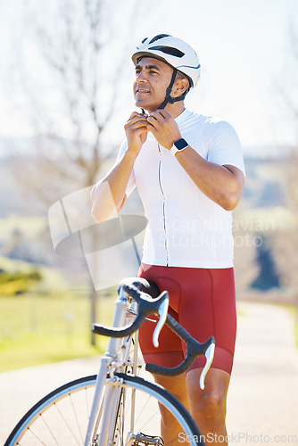 Image of Bicycle, helmet and man cycling in a competition, fitness training or marathon or sports adventure with blue sky. Gear, athlete and safety in outdoor cycle, bike ride or exercise in nature or park