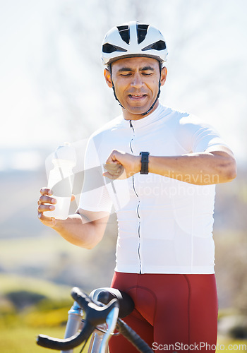 Image of Cycling, bike and man with a smart watch, fitness and exercise with workout goal, training, and water bottle. Male person, biker or athlete outside, checking time and monitor progress with online app