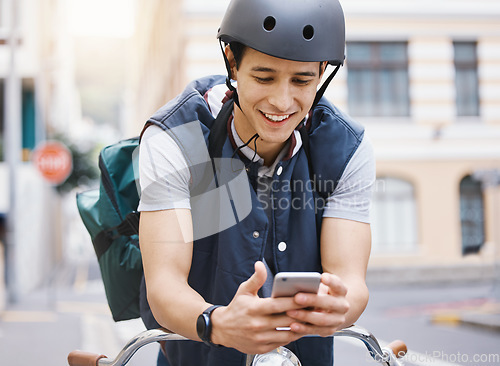 Image of Man, courier bicycle and smile with phone, order or e commerce app for food, product and sustainable transport. Young guy, bike and metro street with texting, chat and eco friendly with logistics job