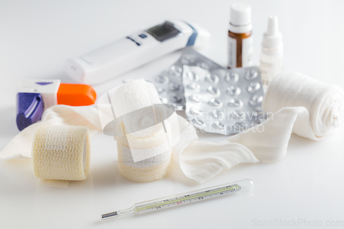 Image of Home pharmacy, first aid kit concept with medical bandages, pills, thermometer and inhalator