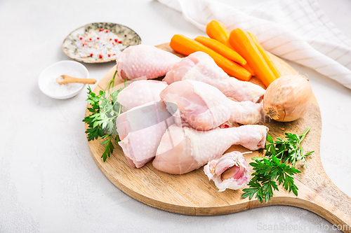 Image of Raw chicken drumsticks with vegetables ans spices prepared for c
