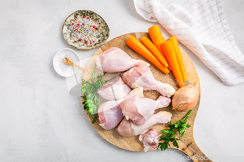 Image of Raw chicken drumsticks with vegetables ans spices prepared for cooking