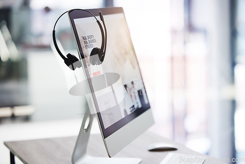 Image of Headset, call center and computer screen in office for consulting, crm and technology communication or help. Workplace, customer service or telemarketing pc on desktop for work, agency or support