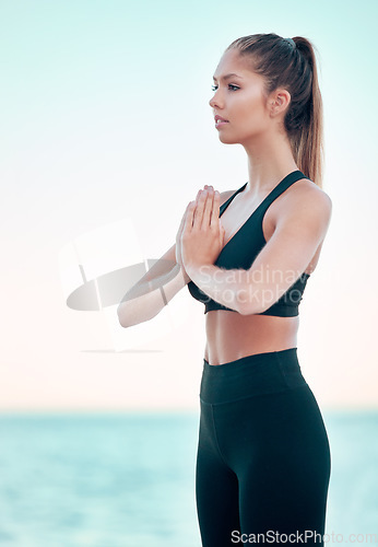 Image of Yoga, namaste and woman at beach, meditation by the ocean with mindfulness, zen with balance and exercise. Female yogi with health, wellness and peace, hands in prayer outdoor and spiritual faith