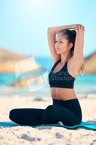 Image of Woman, stretching and yoga at the beach on a mat for self care and wellness in Cape Town. Yogi, meditation and stretch for training by the ocean for zen and spiritual exercise in the outdoor.