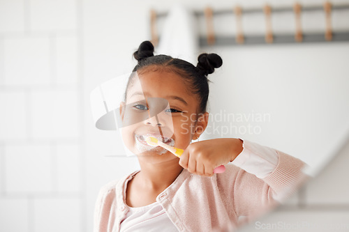 Image of Toothbrush, brushing teeth and child in a home bathroom for dental health and wellness. Face of african girl kid cleaning mouth with a brush in a mirror for morning routine and oral self care