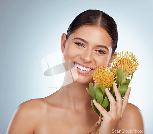 Image of Face, skincare and happy woman with flowers in studio isolated on a white background. Portrait, natural and female model with floral pincushion protea plants for makeup, cosmetics or beauty treatment