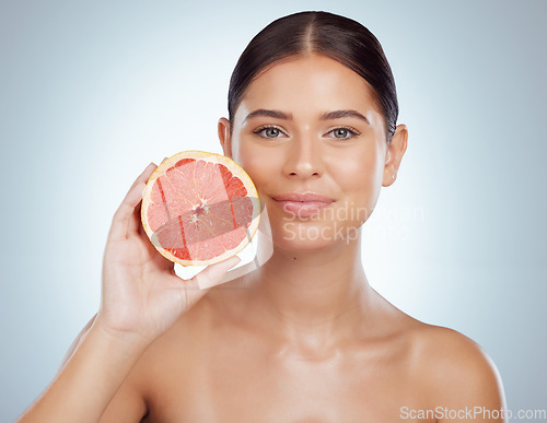 Image of Skincare, face and woman with grapefruit in studio isolated on a white background. Portrait, natural fruit and female model with vitamin c, nutrition and healthy diet, wellness or beauty cosmetics.