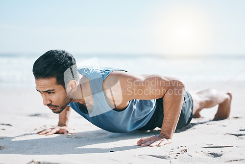 Image of Man, beach and pushup on sand for workout, fitness or exercise for performance in summer sunshine. Young guy, bodybuilder and training for health, wellness and strong body with self care on ground