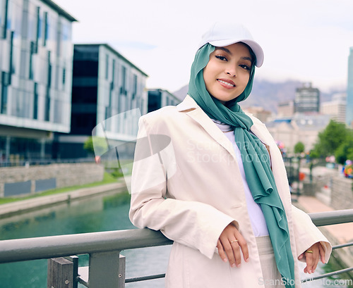 Image of Portrait, fashion or religion with a happy muslim woman in th city wearing a cap and scarf for urban style. Islam, faith or hijab with a trendy young arab person smiling outside in modern clothes