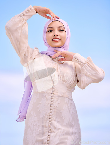 Image of Portrait, fashion or faith with a happy muslim woman on a blue sky background in a scarf for style. Islam, religion and hijab with a trendy young saudi person posing outside in contemporary clothes