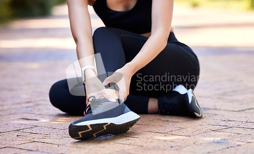 Image of Woman with ankle pain, running injury and fitness with joint fracture, muscle inflammation and health problem. Female athlete injured on run outdoor, hands holding sore foot and healthcare emergency