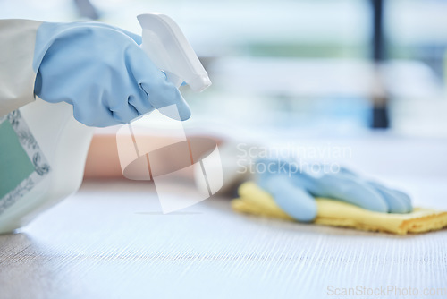 Image of Hands, housekeeper and detergent for cleaning table, hygiene or bacteria and germ removal at home. Hand of person, cleaner or maid spraying and wiping furniture or surface for dust, dirt or stain