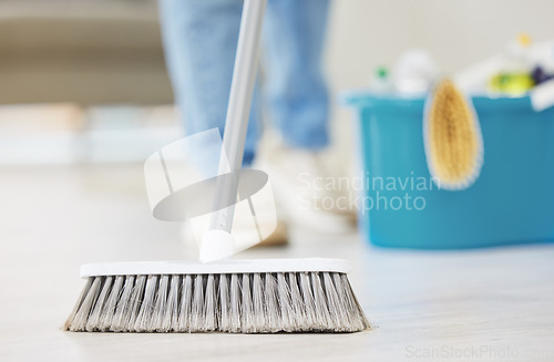 Image of Cleaning, broom and sweeping with a maid in the living room of a home for housework or chores. Floor, sweep and housekeeper with a cleaner in a house to tidy for hygiene during a spring clean closeup