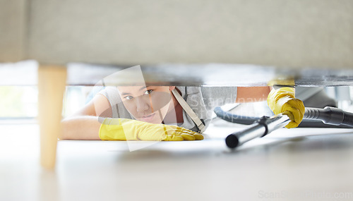 Image of Vacuum, floor and cleaning with a woman housekeeper using equipment to remove bacteria in a home. Safety, sofa and hygiene with a young female cleaner working in a house living room for service