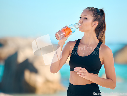 Image of Athlete, woman and drinking water at the beach for fitness, exercise or training at the sea. Girl, person and drink from bottle in outdoor workout, yoga and calm break or rest in summer exercising