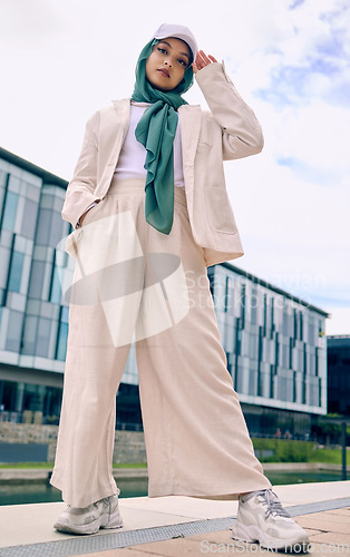 Image of Portrait, city fashion or religion with a muslim woman outdoor in a cap and scarf for contemporary style. Islam, faith or hijab with a trendy young arab female person posing outside in urban clothes