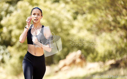 Image of Fitness, woman and listening to music for running, exercise or cardio workout in nature outdoors. Fit, active and sport female person, athlete or runner exercising with earphones in training or run