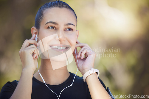 Image of Earphones, runner or happy woman streaming music to start training, workout or running exercise in park. Smile, thinking or healthy sports girl athlete listening to radio or podcast about fitness