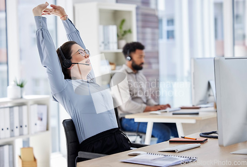 Image of Customer service, woman with headset and stretching her arms at her desk with a computer of modern workplace. Online communication, telemarketing and female call center agent stretch for fatigue