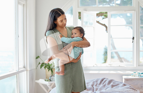 Image of Mother, baby and holding kid in home for love, care and quality time together for childcare, growth and development. Mom, infant and carrying newborn girl in arms for support, comfort or nursery room