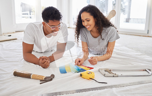 Image of Paint, renovation and choice with a couple in their new home together for a remodeling project. Construction, real estate or property improvement with a man and woman looking at a color pallet