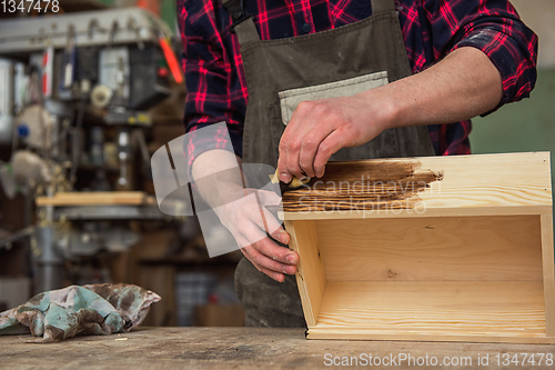 Image of Carpenter painting wooden