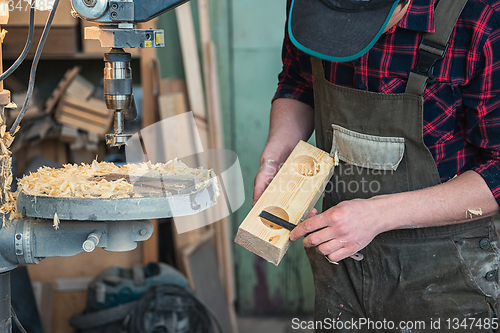 Image of Carpenters with electric drill machine drilling wooden board