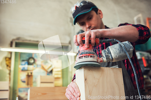 Image of Worker grinds the wood box