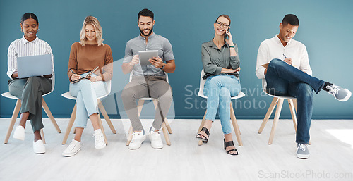 Image of Group, business people and tech by wall for interview with smile, diversity and waiting room for hr recruitment. Men, women and together for networking, human resources and hiring for job at startup