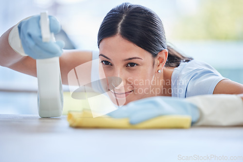 Image of Woman, housekeeper and detergent for cleaning table, hygiene or bacteria and germ removal at home. Female person, cleaner or maid spraying and wiping furniture or surface for dust, dirt or stain