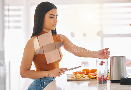 Image of Fruit, smoothie and blender with woman in kitchen for gut health, diet and breakfast. Wellness, detox and nutrition with female person at home for cooking, juice and weight loss milkshake