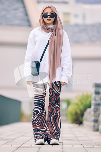 Image of Portrait, fashion or faith with an islamic woman outdoor in a cap and scarf for contemporary style. Islam, faith and hijab with a full length trendy young muslim person outside in modern clothes